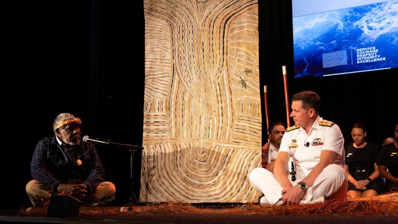 Elder of Madarrpa Clan, Djambawa Marawili, gifts his painting 'Spirit of Sea Rights' to the Chief of Navy, Vice Admiral Mark Hammond, both seated either side of the artwork, at the Indo-Pacific Sea Power Conference, Sydney, 2023.