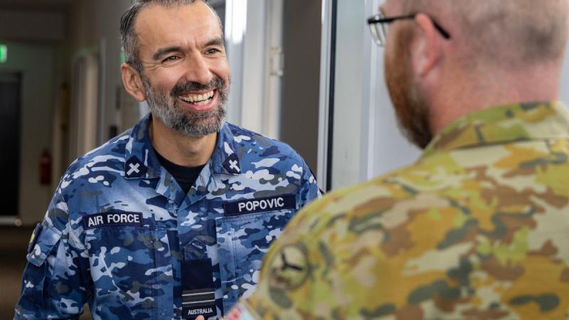 Air Force Chaplain Miljan Popovic, from 23 Squadron, speaks with an aviator at RAAF Base Amberley, Queensland.