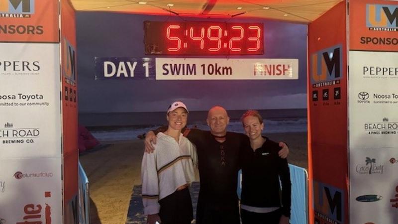 Corporal Tahlia Stockley stands with athlete Ben, and performance sport dietitian Kelsey, at the finish line of UltraMan Australia Day 1 in Noosa, Queensland.