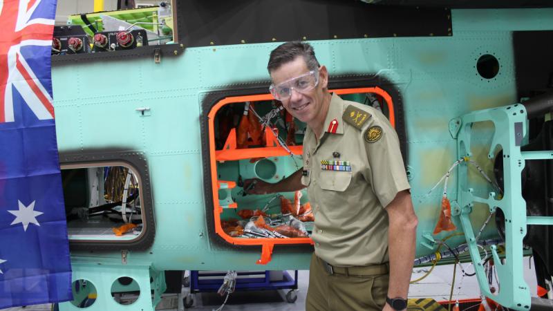 Head of Joint Aviation Systems Division, Major General Jeremy King, signs the fuselage of one of Australia's first four AH-64E Apache helicopters.