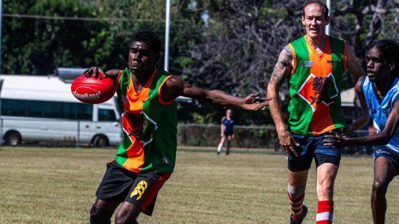 Army soldiers Private Kamahl Koorabubba, left, and Corporal Jake Lindemann, centre right, from the North-West Mobile Force Aussie rules football team, in action during the Barunga Festival competition near Katherine, NT.