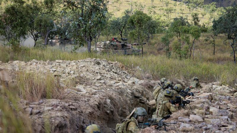 Soldiers from the 1st Battalion, the Royal Australian Regiment, conduct a trench clearance, supported by 2nd Cavalry Regiment M1A1 Abrams main battle tanks, as part of Exercise Brolga Sprint at Townsville Field Training Area, Qld.