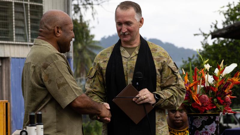 Australian Army officer Chaplain Craig Roberts, delivers school supplies to the principal of Igam Barracks Academy, Philip Tipora, in Lae, Papua New Guinea.