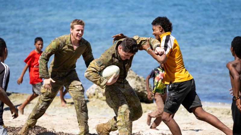 Australian Army soldiers Bombardier Ben Caton-Thomas, left, and Lance Bombardier Isaac Osborne-O'Keefe, from 4th Regiment, Royal Australian Artillery, play rugby with the community while on Mobile Training Team - Bravo at Kouderika, Papua New Guinea.