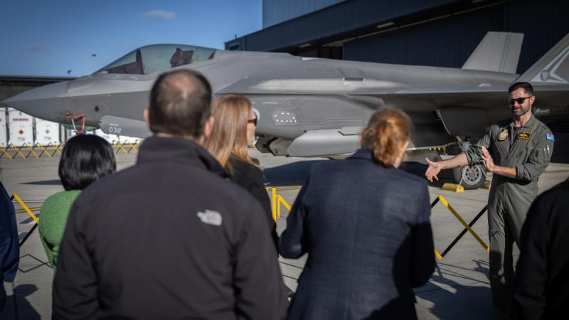 Instructor pilot Squadron Leader Paul Anderton briefs senior Australian Public Service members on the Joint Strike Fighter program during a tour of 2 Operational Conversion Unit at RAAF Base Williamtown, NSW.