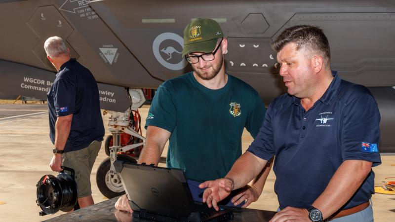 Leading Aircraftman Jasper Poole, a 77 Squadron  avionics technician, speaks with Glen Searson, from F-35 Single Information Environment Operations, about support to F-35A Lightning II at RAAF Base Darwin. 
