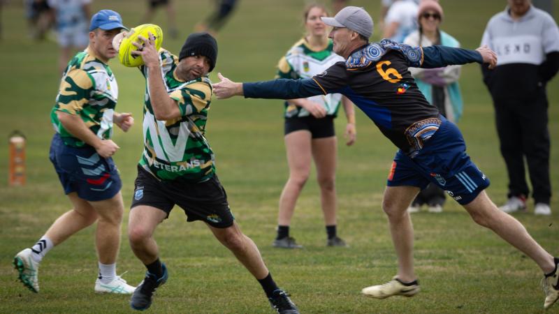 Air Force officer Flight Lieutenant James Evans avoids the opposition during the NAIDOC Cup held in Canberra. 