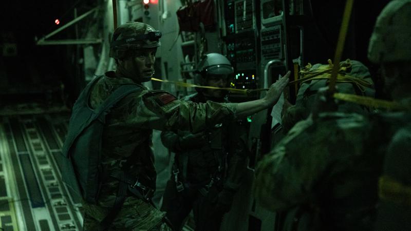 Paratroopers prepare to jump from an Australian aircraft at night. 