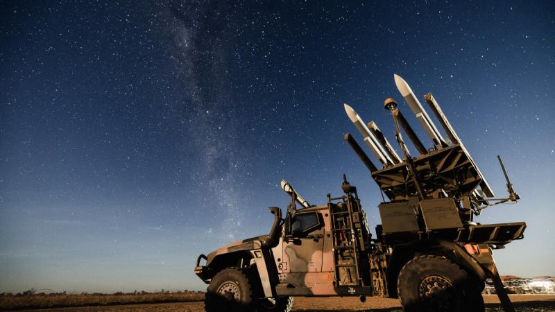 An Army high mobility launcher against a night sky.