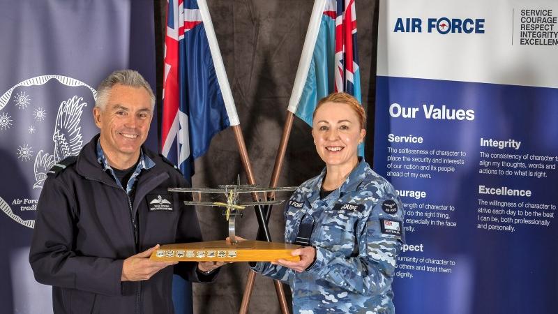 Commander Air Force Training Group, Air Commodore David Strong, presents the Sir Lawrence Wackett Innovation in Training Trophy to Commanding Officer of Officer's Training School, Wing Commander Samantha Couper. 
