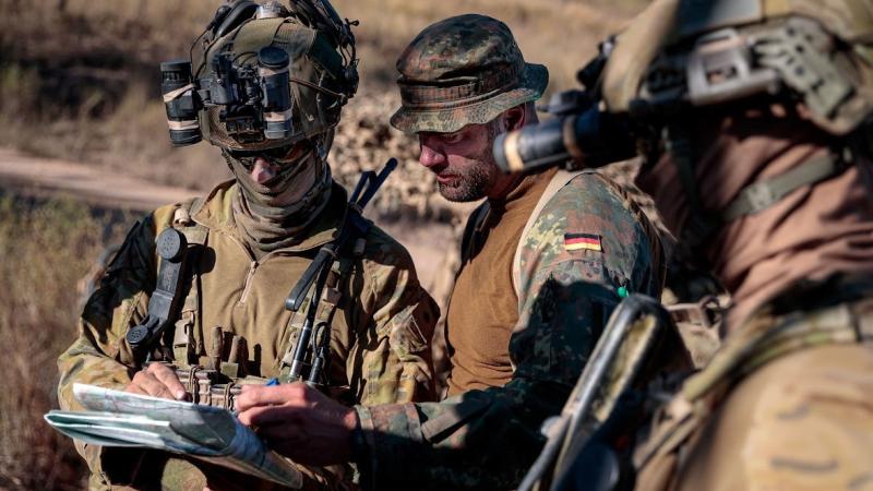 An Australian Army officer, of 3rd Brigade, examines a map of Townsville Field Training Area alongside an officer from the German Army as part of Exercise Talisman Sabre