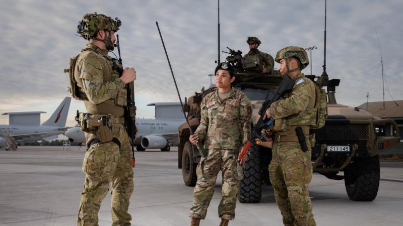 Left to right, Corporal Dillon Walker, from 2 Security Forces Squadron, talks to Senior Airman Brittany Palomo, from the US Air Force, and Leading Aircraftman John Stratford, from 13 Squadron Security Forces, on the flight line at RAAF Base Darwin during Exercise Talisman Sabre 2025.