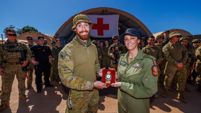 Royal Australian Air Force intensive care nursing officer Flight Lieutenant Ben Jenkins presents a plaque to Royal Canadian Air Force Critical Care Air Transport Team Senior Nursing Officer, Major Melanie Speichts, at the Role 2 Hospital.