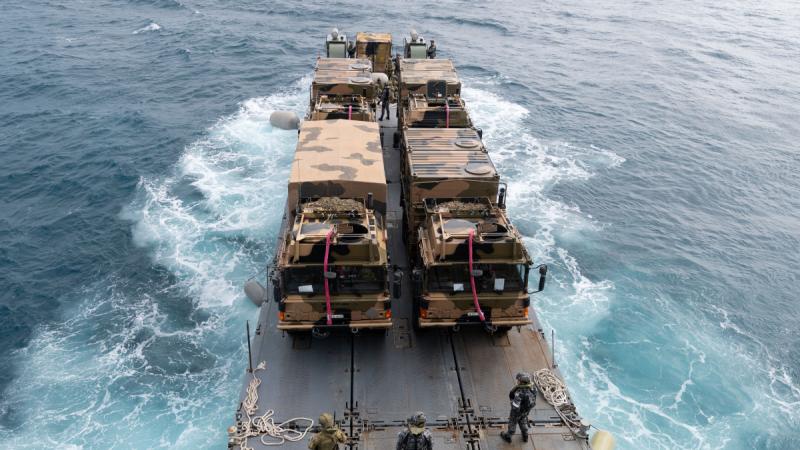 Army trucks and personnel on board a mexefloat.