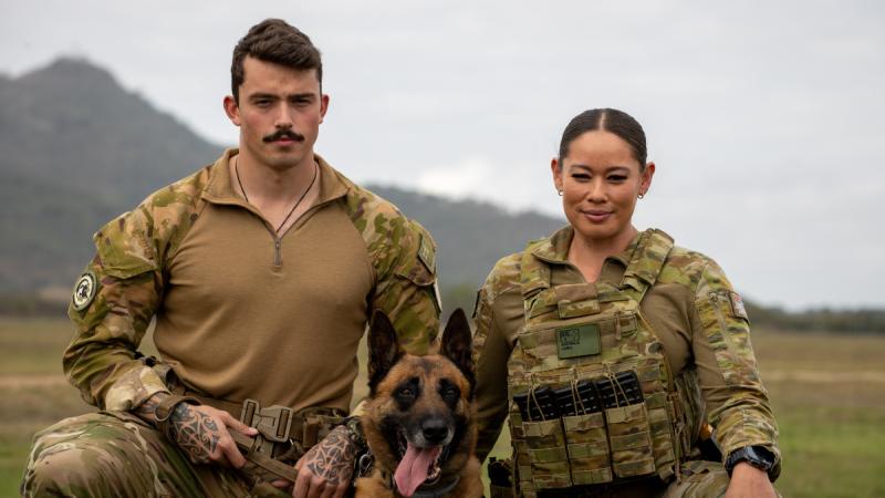 Royal New Zealand Air Force military working dog handler Aircraftman Dylan McClintock, left,  and Keno, join Royal Australian Air Force Corporal Renee Cahill, from 27 Squadron Security Flight, at RAAF Base Townsville.