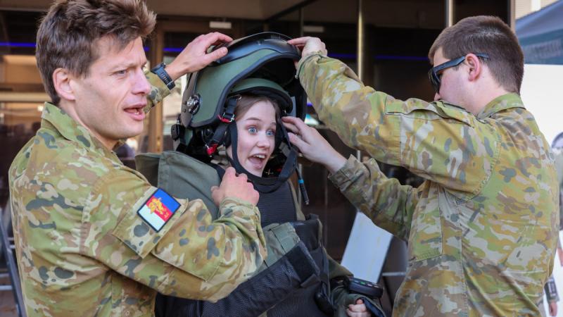 A member of public tries on a bomb disposal suit at ADFA Open Day.