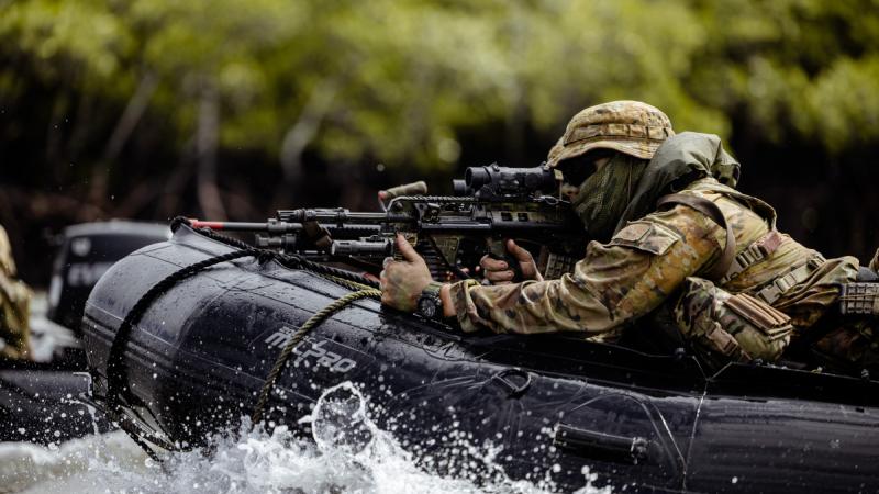 A soldier aboard a small boat operations during Exercise Black Cutlass at Cowley Beach Training Area.