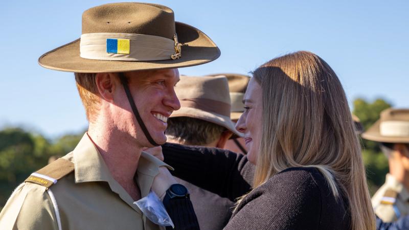 A PTOCP graduate smiles widely as a loved one puts his rank slides on him for the first time.