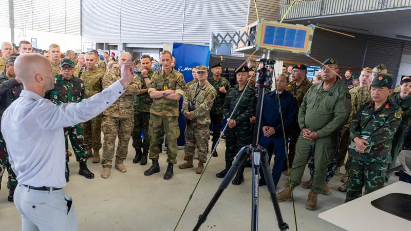 Defence force officials from partner nations observe a capability demonstration during the Science and Technology Showcase at the Monash Centre, Gallipoli Barracks.