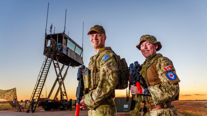 A Royal Australian Air Force air traffic controller with a Royal Canadian Air Force air traffic controller at the mobile air operations tower at RAAF Base Curtin.