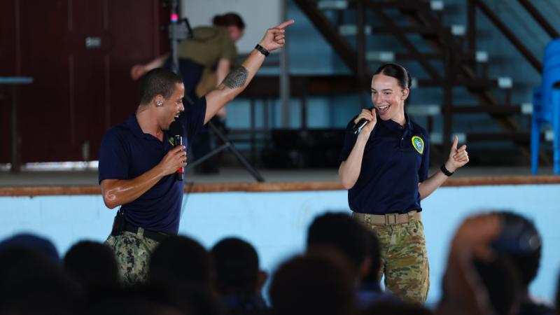 Musicians Sartori and Bree on stage performing in front of an audience.