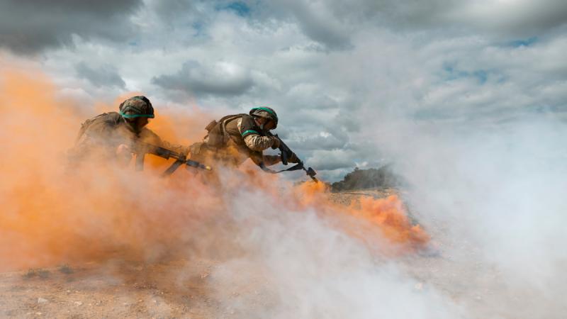  Ukraine soldiers assault a trench amid orange and white smoke as part of Operation Kudu