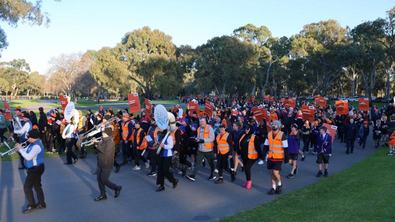 People march through a park for the Hutt Street Centre’s Walk a Mile in My Boots annual charity event.
