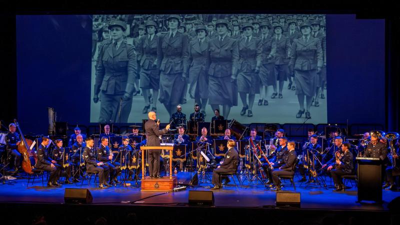 The Air Force Band plays at Canberra Theatre Centre under a projected image of Air Force women marching during World War 2.