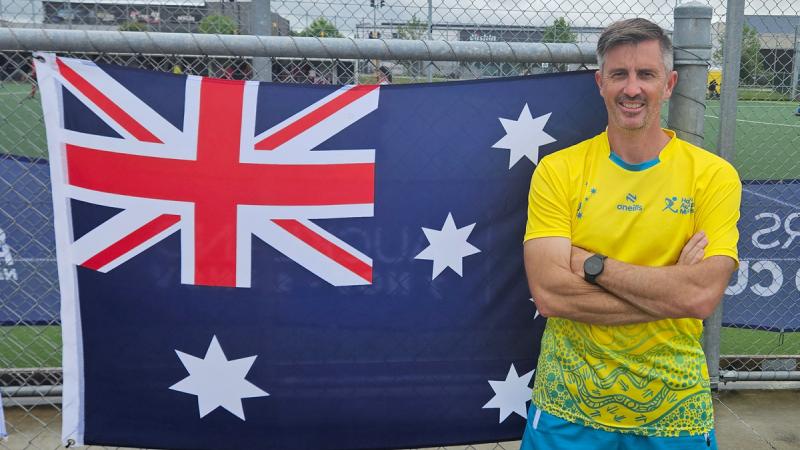 Warrant Officer Clint Bird in front of the Australian flag.