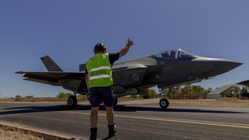 A ground crew member in high-vis gives thumbs up to an F-35A Lightning II aircraft arriving at RAAF Base Tindal.