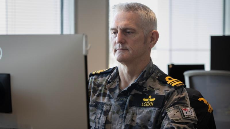 Navy officer works at a computer at Defence College of Intelligence.