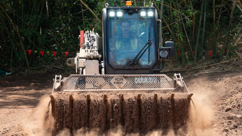 A man operating a bulldozer in a tropical setting.