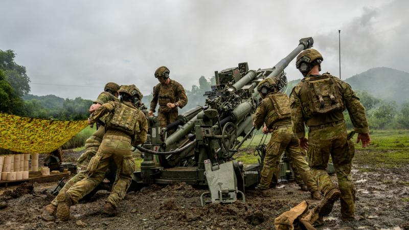 Australian soldiers firing a howitzer.