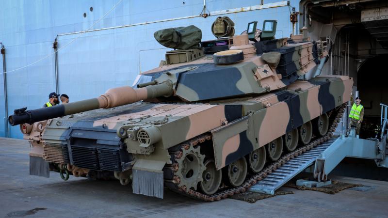 Australian Army M1A2 Abrams tank reversing up a short ramp onto HMAS Adelaide.