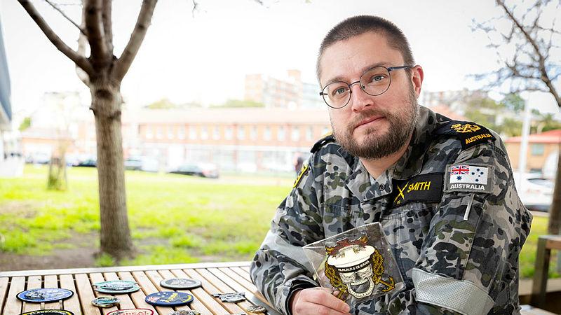 A man in uniform displays military patches.