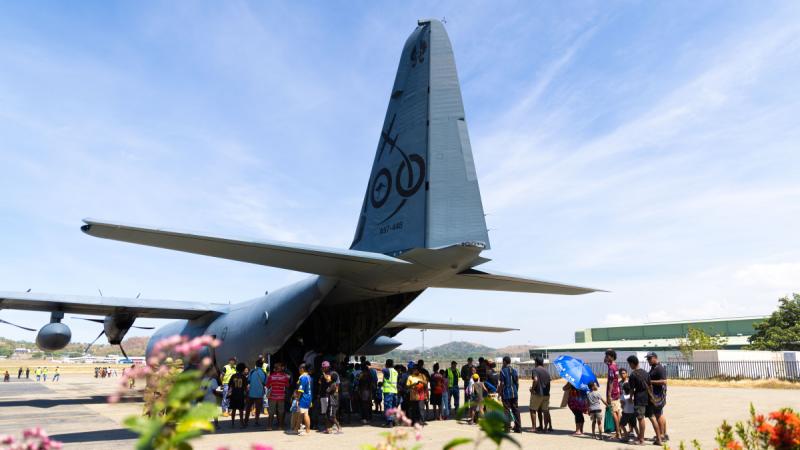 People in a short queue to see an aircraft.