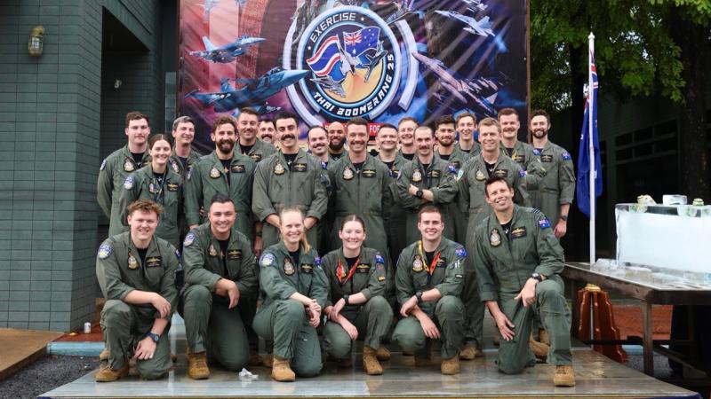 A group of Royal Australian Air Force’s personnel in front of Exercise Thai Boomerang 2025 signage.