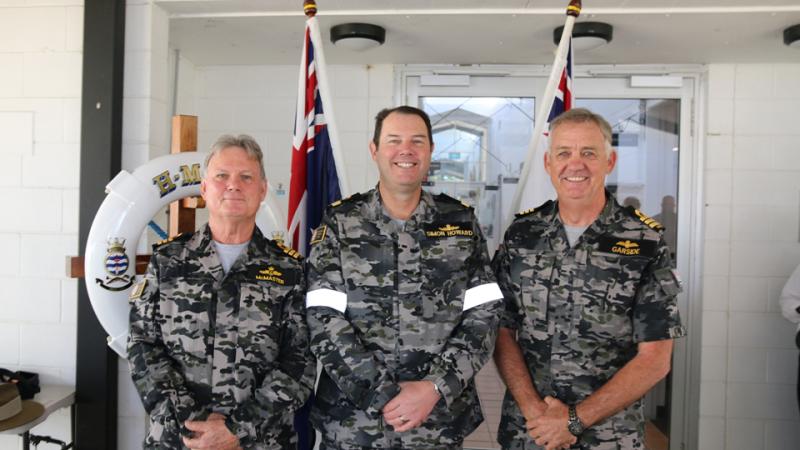 Three men in Navy uniform standing side by side.