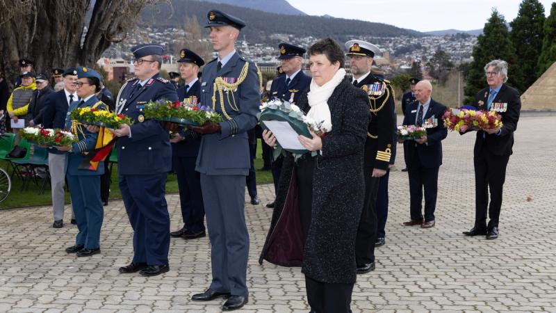 Civilians and uniformed personnel line up to lay wreaths in Hobart.