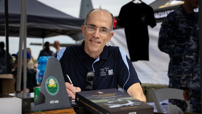 Air Commodore Bill Kourelakos (retired) with his latest book "The Air Mobility Workhorse: C-130 Hercules Aircraft in Royal Australian Air Force (RAAF) Service" during the RAAF Richmond Air Show 2025, at RAAF Base Richmond, NSW. Photo by LACW Aiesha White-Kratz.