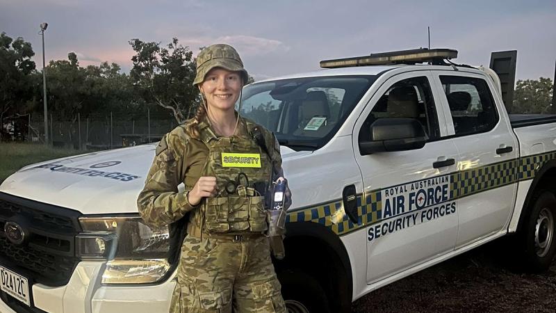 An Air Force member stands in front of a four-wheel drive.