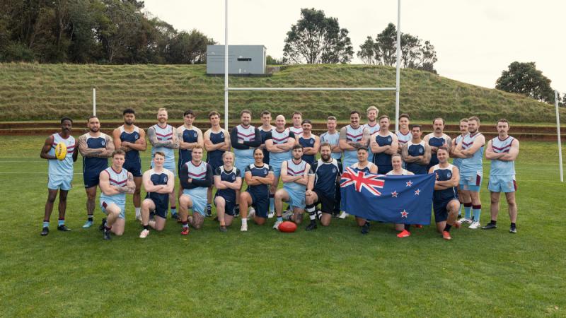 HMAS Canberra and Royal New Zealand Navy players pose for a group photo before a friendly Australian Rules match in Wellington, New Zealand.