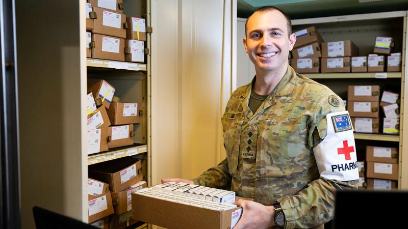 Australian Army pharmacist Captain Jonathan Seib handles drugs on board HMAS Canberra.