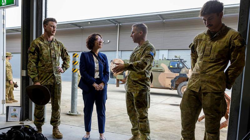 A professor talks with soldiers at a capability display.