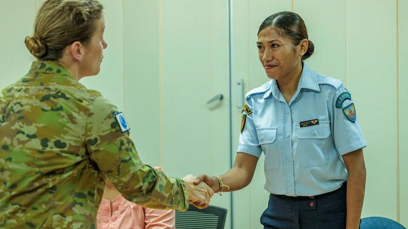 A female Australian Army member shakes hands with a female Timor-Leste member.