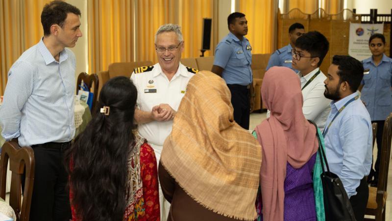 A group of men and women talking at a social function.