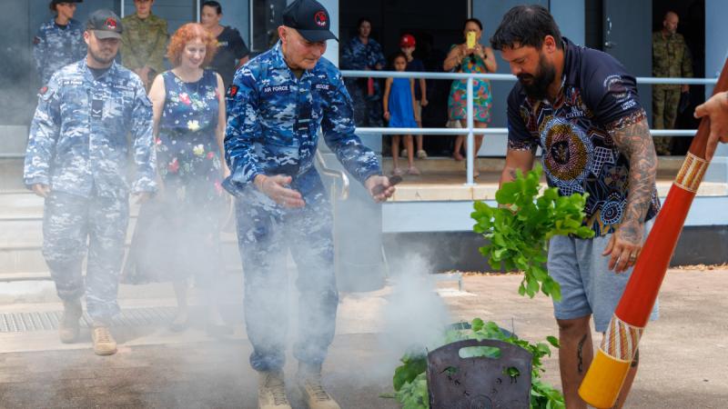 Air Force personnel and guests attend a smoking ceremony at RAAF Base Darwin.