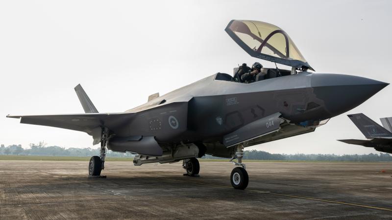 An F-35A on the tarmac, with its entry hatch open and a pilot sitting inside.