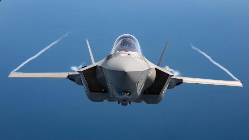 A Royal Australian Air Force F-35A Lightning II captured in mid-flight against plain blue sky.