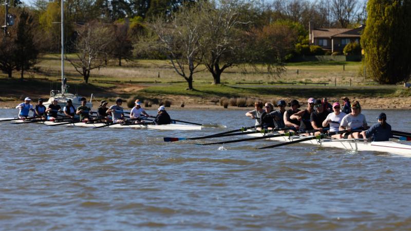 Two ADF crews compete in eight-person rowing on Lake Burley Griffin.